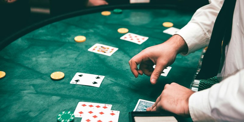 Casino scene with dealer and players, featuring cards and chips, creating a suspenseful atmosphere.