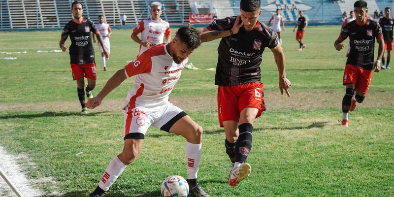 Competitive soccer match with players in action at an outdoor football field.