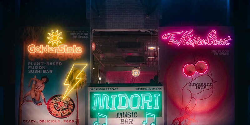 Explore Bangkok's vibrant nightlife with neon signs lighting up local bars and shops.